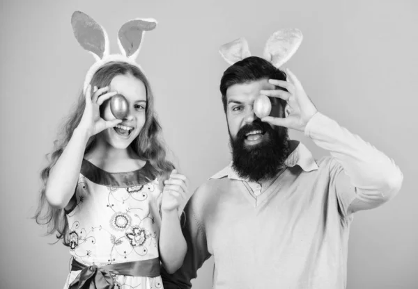 Esperamos celebrar la Pascua. Celebración familiar. Padre e hijo con huevos de Pascua de colores. Familia de padre e hija en orejas de conejo de Pascua. Familia feliz. Familia en la caza anual de huevos de Pascua —  Fotos de Stock