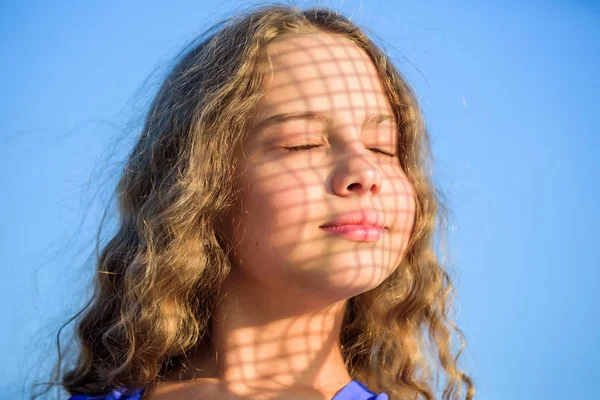 Fais attention. Soins d'été. Concept de crème solaire. Enfant heureux avec la lumière du soleil chaud regarde fond bleu ciel détendu. Prendre soin de la peau mettre des cosmétiques crème solaire. Jeune fille se relaxant à l'extérieur. Filtre UV crème solaire — Photo