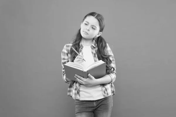 Geboren om te lezen. Schattig klein meisje leren om te lezen en schrijven op oranje achtergrond. Leuk klein kind kan een boek lezen. Het hebben van vrije tijd om te lezen — Stockfoto