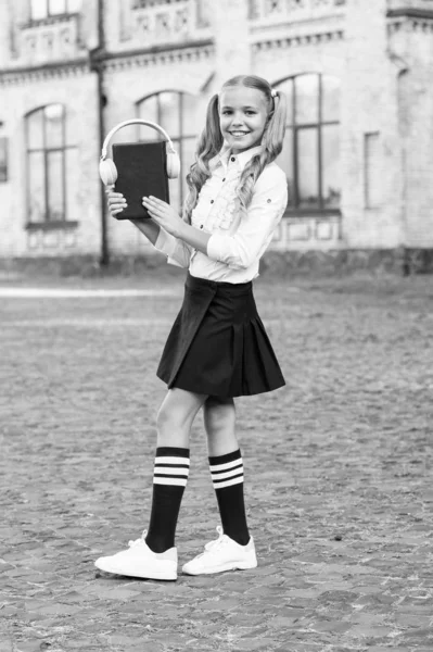 Innovativt livslångt lärande. med headsetteknik. liten lycklig flicka Lyssna e-bok. elev i retro Uniform lyssna ljud bok. e-Learning. Vintage Kid mode. gammal skola musik. tillbaka till skolan — Stockfoto