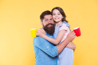 Susuz kalma. Mutlu aile sütlü çay içmeyi sever. Küçük kız ve baba sabah içiyorlar. Küçük çocuk ve sakallı adam bardakları tutuyor. Sağlıklı içme alışkanlıkları. Kahvaltı.