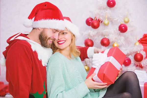 Γιορτάζει τα Χριστούγεννα μαζί. Αγάπη ζευγάρι αγκαλιά χαμογελώντας κατά την αποσυμπίεση τα δώρα με φόντο χριστουγεννιάτικο δέντρο. Οικογενειακή παράδοση των Χριστουγέννων. Ερωτευμένο ζευγάρι απολαύσετε εορτασμός διακοπών Χριστουγέννων — Φωτογραφία Αρχείου