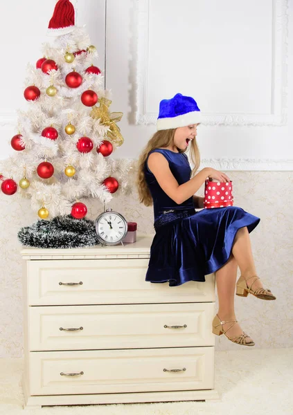 Ώρα να ανοίξουμε χριστουγεννιάτικα δώρα. Ευτυχισμένο το νέο έτος. Το παιδί γιορτάζει τα Χριστούγεννα στο σπίτι. Το κοριτσάκι κάθεται κοντά στο κουτί δώρου. Μικρό κορίτσι καπέλο santa ενθουσιασμένος για τα Χριστούγεννα δώρο ή δώρο — Φωτογραφία Αρχείου