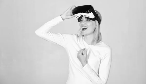 Junge Frau mit einem Virtual-Reality-Headset. erstaunt junge Frau berühren die Luft während der vr Erfahrung. selbstbewusste junge Frau richtet ihr Virtual-Reality-Headset ein und lächelt. — Stockfoto