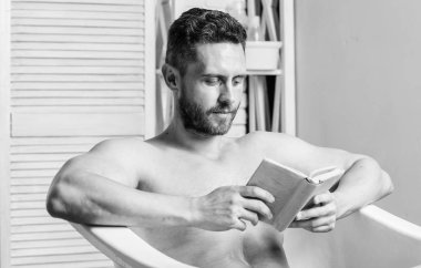 Tam bir rahatlama. Kişisel hijyen. Sinir sistemi banyo yarar. Rahatla konsepti. Adam kas gövde küvet dinlenmek ve kitap okuyun. Sıcak banyoda dinlenirken rahat adam kitap okuyor. Evde rahatlayın