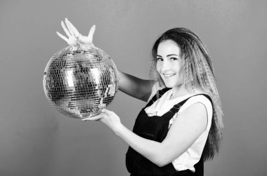 Aynalar disko atmosferini yansıtıyor. Partiye ne dersin? Küçük bir parti kimseyi öldürmez. Düşene kadar dans et. Neşeli kadın disko topu tutuyor. Gece kulübü. Retro müzik. Partiye davet edilen kız