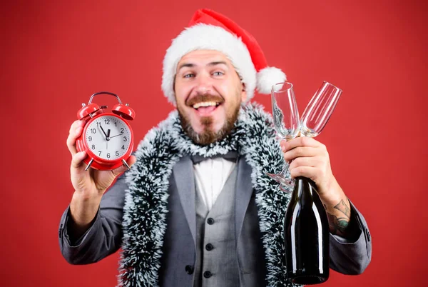 Middernacht. Gelukkig nieuwjaar. Zakenman Santa hoed met knutsel en klok. Kerstmis is een leuke tijd. Mannen drinken champagne uit glazen. Tijd voor de wintervakantie. bebaarde man viert kerstfeest — Stockfoto