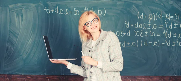 Навчитися легко. Вчителька в окулярах тримає ноутбук, що серфінгує Інтернет. Освітянка розумна розумна леді з сучасним ноутбуком, що серфінгує в Інтернеті крейдяним фоном. Концепція цифрових технологій — стокове фото