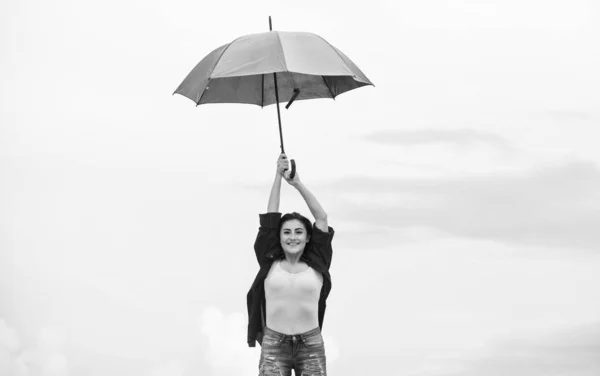 Parachute concept. Good weather. Welcoming fall. Pretty woman with colorful umbrella. Rainbow umbrella. Rainy weather. Good mood. Good vibes. Open minded person. Girl feeling good sky background