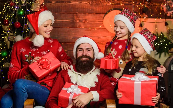 Tradição de Natal. Dia de boxe. Pai barbudo homem e mãe com filhas bonitos árvore de natal fundo. Boas festas. Passa tempo com a tua família. Pais e crianças abrindo presentes de Natal — Fotografia de Stock