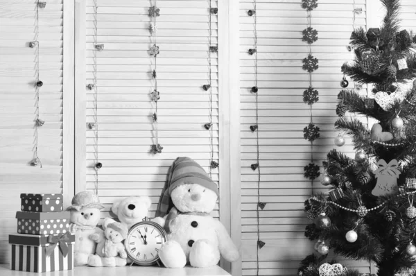 Snögubbar och nallebjörnar nära klockan och julgranen. — Stockfoto