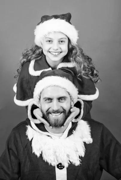 Πίστη στη Σάντα αποτελεί πιο μαγικό μέρος της παιδικής ηλικίας. Κορίτσι μικρό χαριτωμένο παιδί και γενειοφόρος πατέρας φορούν κοστούμι Σάντα. Χριστουγεννιάτικο πάρτι. Πώς να Οδηγός γονέων του Αϊ-Βασίλη. Ο μπαμπάς μου είναι Άγιος Βασίλης — Φωτογραφία Αρχείου