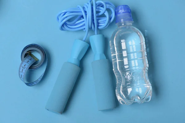 Springseil in Cyan-Farbe auf blauem Hintergrund, Draufsicht. — Stockfoto