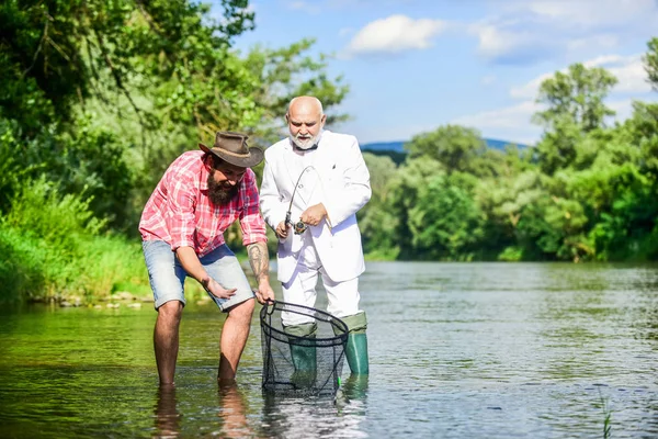 Simplemente estar cerca. Dos amigos pescando juntos. padre jubilado e hijo barbudo maduro. feliz amistad de pescadores. pasatiempo pez mosca de hombre de negocios. pesca de jubilación. Concepto de captura y pesca —  Fotos de Stock