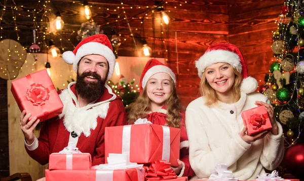 Traje del padre Santa Claus con la familia celebrando la Navidad. Hija encantadora con padres con sombrero de Santa. Regalos de Santa. Cuidar a la gente más cercana. Concepto de unidad. Amor y bondad — Foto de Stock