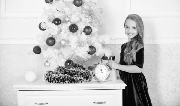 Ultimi preparativi. Il bambino festeggia il Natale a casa. Il giorno dell'anno preferito. Festeggiamenti. Incredibilmente emozionati per Natale. Ragazza vicino all'albero di Natale in attesa orologio di mezzanotte — Foto Stock