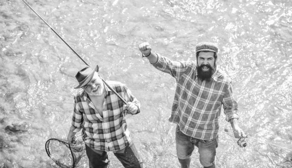 Lazer. Equipamentos de pesca dos pescadores. Atividades desportivas de passatempo. Os amigos dos pescadores estão no rio. Peixes normalmente capturados em estado selvagem. Homens barbudos pescadores. Fins de semana feitos para pescar. Dia ensolarado ativo — Fotografia de Stock