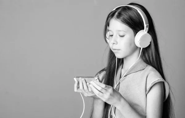 Girl listen music modern headphones and smartphone. Listen for free. Music subscription. Enjoy music concept. Music app. Audio book. Educative content. Study english language with audio lessons
