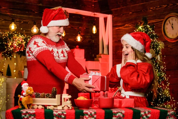 Ο Άγιος Βασίλης γενναιόδωρος. Παιδί απολαμβάνουν τα Χριστούγεννα με γενειοφόρο παππού Santa Claus. Ευτυχία και χαρά. Απονομή καλοσύνης. Ο Άγιος Βασίλης φέρνει δώρα κοριτσάκι. Χαρούμενη γιορτή. Εορταστική παράδοση — Φωτογραφία Αρχείου