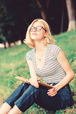 kitap açık öğrenci kız. parkta kitap okuyan bir kadın. ilginç bir hikaye. Rahatlayın ve yeni bilgiler alın. okumak benim hobim. Yaz çalışması. roman yazarından esinlenerek. Evde eğitim konsepti