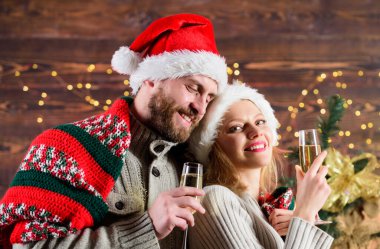 Aşklarını ifade ediyorlar. Birbirine aşık çift Noel Baba şapkası. Hediye zamanı. Mutlu noeller. Aile şampanyası. Selamlama zamanı. Çift kendini rahat hissediyor. Mutlu yıllar. Kadınlar ve erkekler xmas 'ı sever