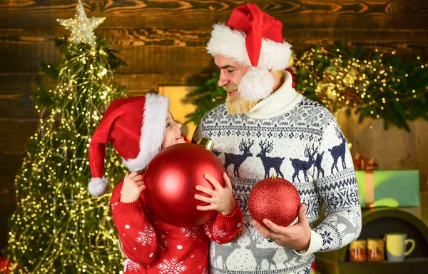 Aile evi ve Noel ağacını süsler. Kış Xmas tatili. Mutlu yıllar. Sakallı baba ve küçük kız Noel Baba şapkası. Komik örülmüş kazak. Baba ve kızı Noel 'i kutluyor. Birlikte xmas partisi — Stok fotoğraf