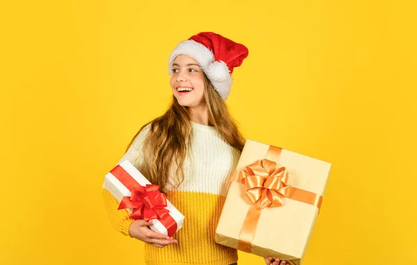 Χριστουγεννιάτικα ψώνια online. Ώρα για έκπτωση. Χαμογελαστή παιδί αναμονή αγοράς. δώρα και δώρα από τον Άγιο Βασίλη. Μικρό κορίτσι Σάντα στο κίτρινο φόντο. Χριστουγεννιάτικη γιορτή. Ευτυχισμένο το νέο έτος — Φωτογραφία Αρχείου
