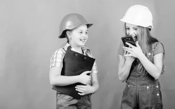 Día del Trabajo. 1 de mayo. proyecto escolar. Inspector Foreman. Reparar. Niños pequeños en casco con tableta. niñas pequeñas que reparan juntos en el taller. gritándole al trabajador en llamada telefónica. discusión de problemas —  Fotos de Stock