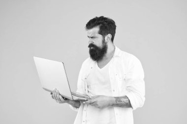 Çok çalışmak. Bilgisayarlı programcı. İnternette sörf yapan acımasız bir adam. hipster defter kullanıyor. Sakallı adam dizüstü bilgisayar sarı arka plan. İnternetten alışveriş. Çevik iş konsepti. dijital dünyada eğitim