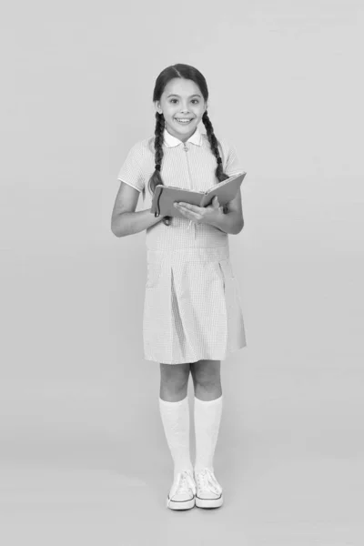 Παιδικές αναμνήσεις. βιβλίο της εγκυκλοπαίδεια για τα παιδιά. κορίτσι αγαπά τη λογοτεχνία. παλιάς σχολής. ευτυχισμένο κοριτσάκι με ρετρό στολή. vintage Παιδική μόδα. πίσω στο σχολείο. μικρό κορίτσι κρατήσει το βιβλίο εργασίας ή το σημειωματάριο — Φωτογραφία Αρχείου