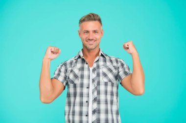 Sıradan ve güçlü. Güçlü adam kollarını mavi arka planda açar. Sıradan tarzda yakışıklı bir adam. Sıradan moda trendleri. Moda ve tarz. Rahat hissediyorum. Sıradan görünüş