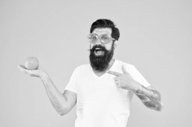 Yaz havasında sakallı hipster. Neşeli adam olgun portakal narenciye tutun. Yaz tatili. Sarı arka planda turuncu güneş gözlüklü adam sakallı hipster. Ferahlık kaynağı. Yaz beslenmesi