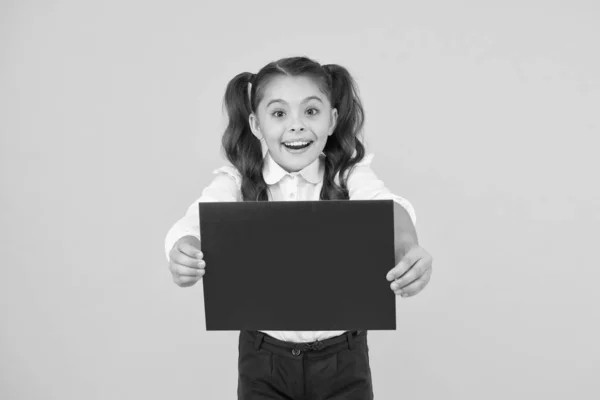 Terug naar school concept. Schoolmeisje pupil show poster. Schoolmeisje houdt poster kopieerruimte. Nieuws promotie van informatie. Binnenkort. Kijk hier. Meisjesschooluniform poster. Veranderingen komen eraan — Stockfoto