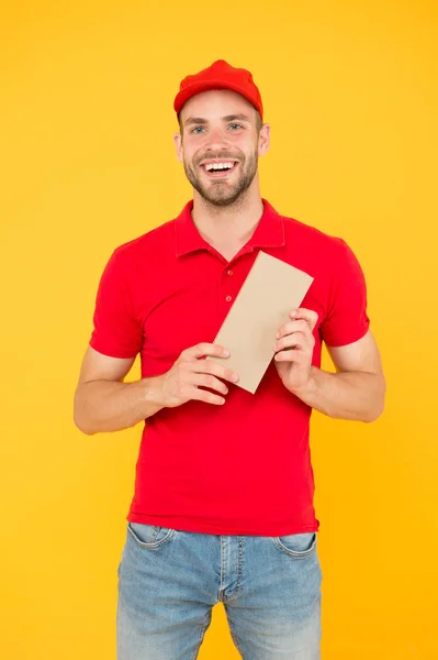 Future Delivered on Time. Giving perfect service. Courier delivery. Postman worker. Man red cap yellow background. Transportation agency. Transportation goods. Transportation concept. Transporting