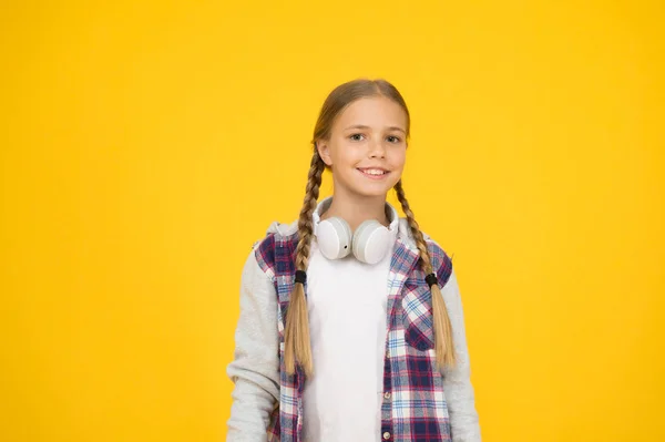 Usługi streamingowe. Szczęśliwa dziewczynka w nowoczesnych słuchawkach. Miłej zabawy. Bezprzewodowość oznacza wolność. Słuchawki z technologią bezprzewodową. Małe dziecko słuchające muzyki nowoczesne bezprzewodowe słuchawki — Zdjęcie stockowe