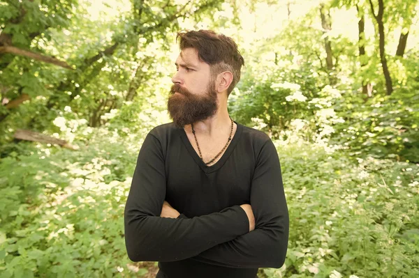 Wild nature. Man bearded hipster bright foliage background. Guy relax in forest. Exploring nature. Handsome man with beard and mustache in nature. Brutality of jungles concept. Summer heat season