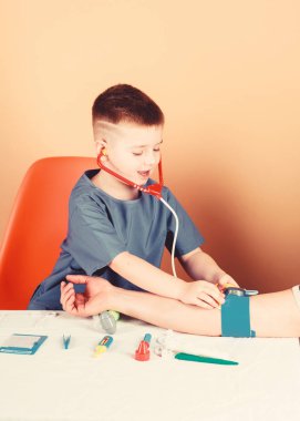 Hastane. İlaç ve sağlık. Çocuk doktoru stajyeri. Tıp üniformalı küçük bir çocuk. Hemşire laboratuvar asistanı. Aile doktoru. Tedavi reçetesi. Steteskoplu çocuk doktoru. Doktor hastanede..