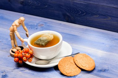 Sağlık hizmetleri kocakarı ilaçları. Mavi arka planda bir fincan çay yakın plan. Lezzetli gurme tadı. Kafe menüsü. Böğürtlen çayı. Seramik fincan sıcak demlenmiş çay içeceği. Aromatik rowanberry içeceği için.