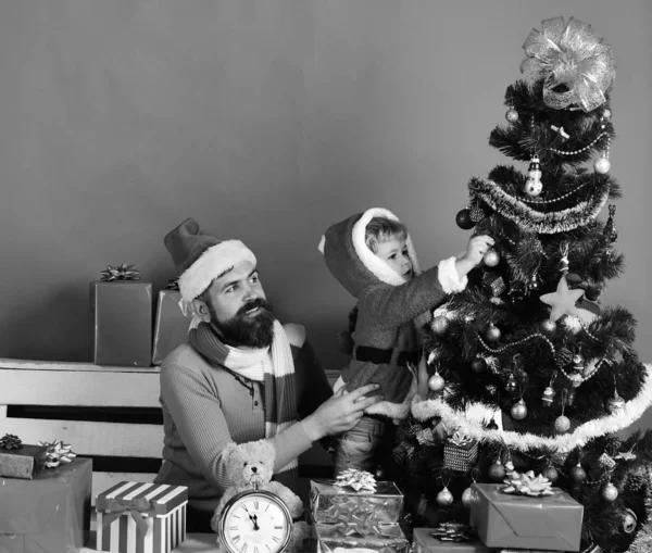 Kerstman en kleine assistent onder geschenkdozen — Stockfoto