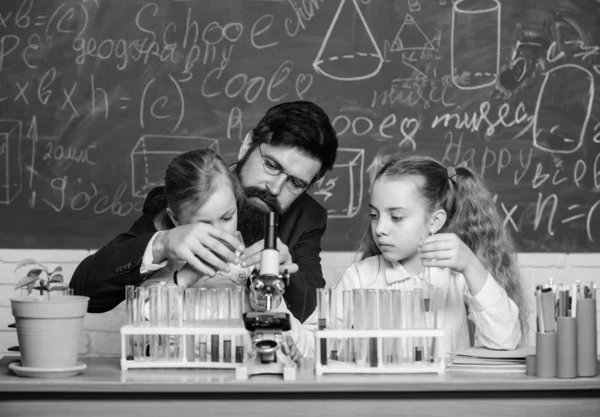 Εξηγώντας τη βιολογία στα παιδιά. Πώς να ενδιαφέρουν τα παιδιά σπουδάζουν. Συναρπαστικό μάθημα βιολογίας. Ο άνθρωπος με γένια δάσκαλος δουλεύει με μικροσκόπιο και δοκιμαστικούς σωλήνες στην τάξη της βιολογίας. Εκπαιδευτικός της βιολογίας — Φωτογραφία Αρχείου
