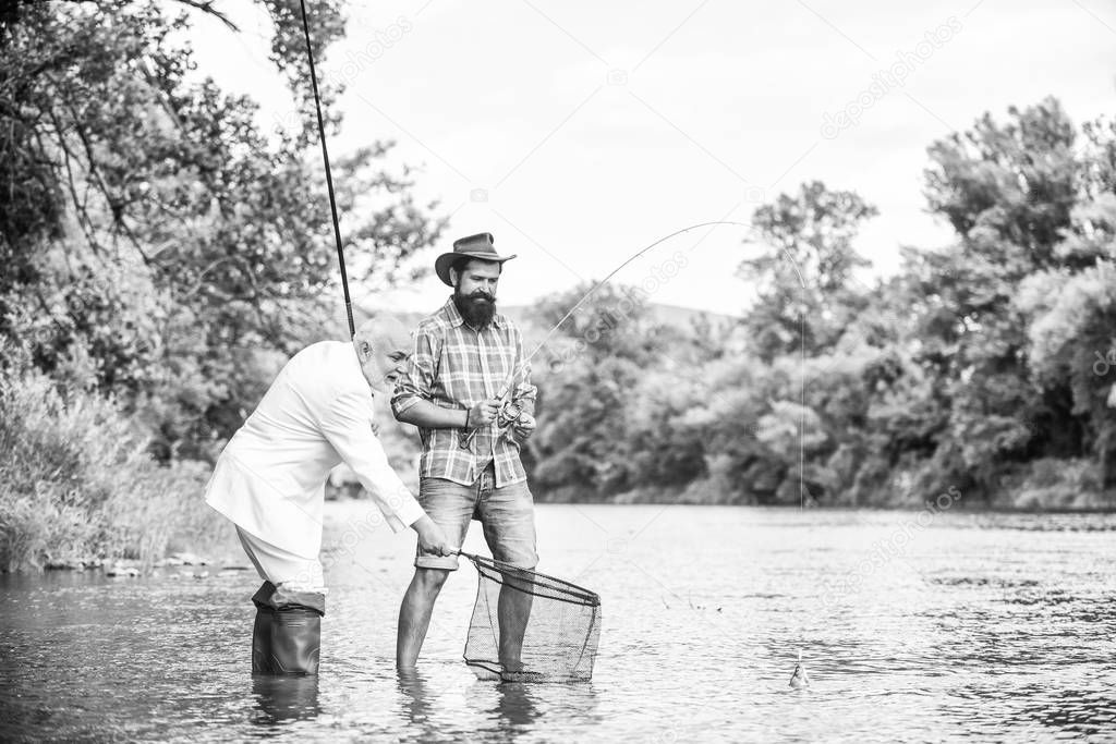 strategy. happy fishermen. Good profit. Fly fishing adventures. friends men with fishing rod and net. retired dad and mature bearded son. hobby of businessman. retirement fishery