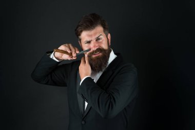 El traşı. Sakallı adam yüz kıllarını siyah arka planda tıraş ediyor. İş adamı traş aletini tutar. Usta berberden profesyonel tıraş. Jiletle tıraş oluyorum. Berber dükkanı.