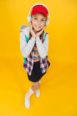 Havalı liseli. Gençlik modası. Neşeli bir genç. Küçük kız uzun saçlı. Ergen yaşam tarzı. Okul günleri. Modern bir genç. Mutlu bir çocukluk. Sevimli hippi ergen çocuk sarı arka plan