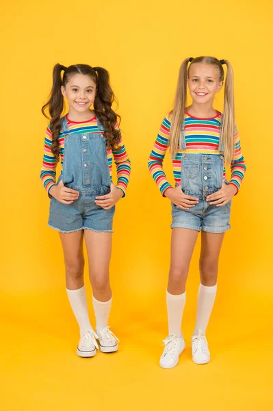 Tendance et fantaisie. Des petites filles portant des vêtements arc-en-ciel. Des tenues assorties. Boutique de mode. Il doit y avoir un accessoire. Des couleurs vibrantes. La mode moderne. Mode pour enfants. Les filles cheveux longs. Enfants mignons mêmes tenues — Photo