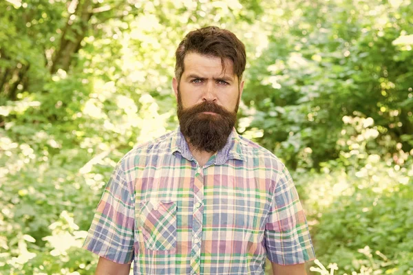 Brutal style trends. Bearded man with brutal look on natural landscape. Caucasian guy with long brutal beard and mustache on summer nature. Brutal hipster wearing casual style outdoor
