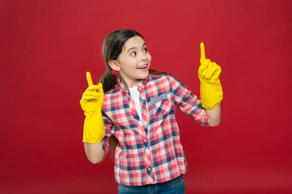 Inspiring changes. Spring cleaning. House cleaning service. Cleaning supplies. Small girl rubber gloves for cleaning red background. Appreciate cleanliness. Clean house. Housekeeping duties