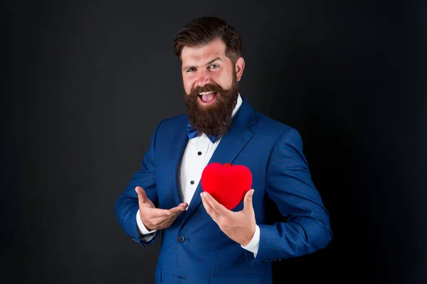 É perfeito. Decoração do dia dos namorados. Homem de smoking com coração vermelho. Celebração de férias. conceito de amor. Dia Mundial do Coração. Um hipster barbudo brutal num fato formal. Homem de negócios de gravata borboleta. Serviços de saúde — Fotografia de Stock