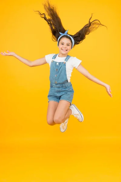 Lleno de energía. Chica activa sentir la libertad. Diversión y relax. sentirse libre. niño despreocupado en vacaciones de verano. Es hora de divertirse. belleza retro en el aire. Salto de felicidad. niña pequeña salto amarillo fondo —  Fotos de Stock