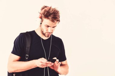 Modern teknolojiyi zevk için kullanmak. Sakin ol. Seksi kaslı adam müzik listesinden müzik dinler. Kulaklıklarınızı takın ve dinlenin. traşsız adam rahatla favori şarkıyla