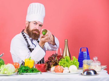 Sakallı adam mutfakta yemek pişirir, mutfak. Vejetaryen. Sakallı olgun şef. Sağlıklı yemek pişirme. Yağlı yemek. Diyet ve organik gıda, vitamin. Şapkalı şef adam. Gizli tat tarifi